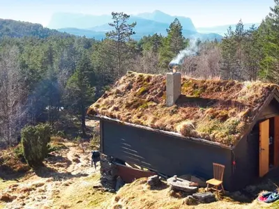 a building with a grass covered roof with a chair at 4 person holiday home in Leirvik i Sogn in Leirvik