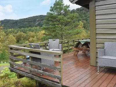 a deck with chairs and a picnic table on a house at 4 person holiday home in Leirvik i Sogn in Leirvik
