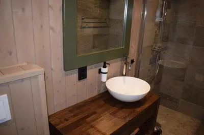 a bathroom with a white sink and a shower at Skeikampen Booking in Svingvoll