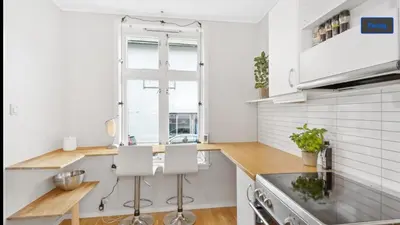 a kitchen with white walls and wooden counter tops at Central apartment in walking distance from the city. in Ålesund