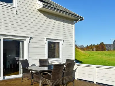 a patio with a table and chairs on a porch at 10 person holiday home in MIDSUND in Midsund