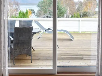 a sliding glass door with a chair on a deck at 10 person holiday home in MIDSUND in Midsund