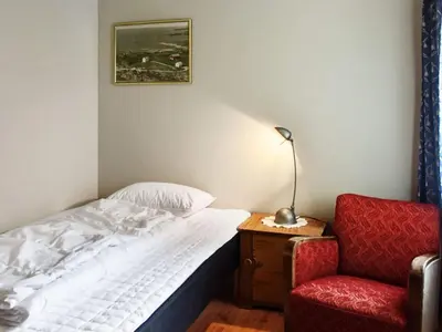a bedroom with a bed and a chair and a lamp at 10 person holiday home in MIDSUND in Midsund