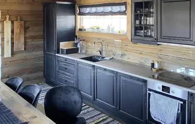 a kitchen with a sink and a counter with chairs at Pet Friendly Home In Hovden I Setesdal in Hovden
