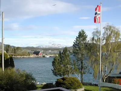 a flag on a pole next to a body of water at 6 person holiday home in averøy-By Traum in Averoy
