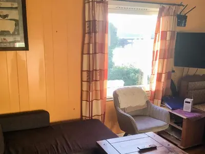 a living room with a couch and a chair and a window at 6 person holiday home in averøy-By Traum in Averoy