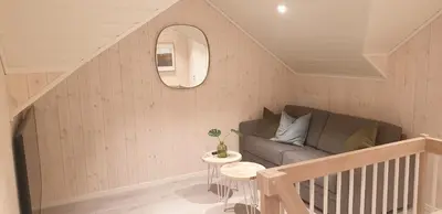 a living room with a couch and a table at New and Exclusive Cottage in Voss with a great view in Skulestadmo
