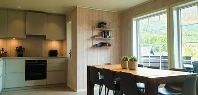 a kitchen with a wooden table and a table and chairs at New and Exclusive Cottage in Voss with a great view in Skulestadmo