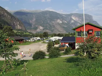 two children walking down a road in front of a mountain at Lunde Camping in Aurland
