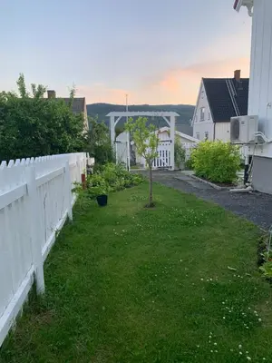 a yard with a white fence and a tree at The Gingerbread House in Lillehammer