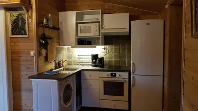 a kitchen with a white refrigerator and a stove at Leilighet 2240 in Haugsvær