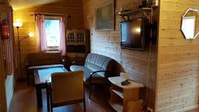 a living room with a couch and a tv on a wall at Leilighet 2240 in Haugsvær