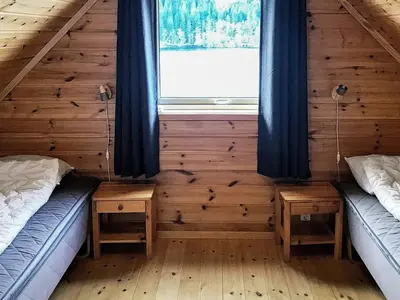 two beds in a wooden room with a window at 6 person holiday home in Seim in Seim