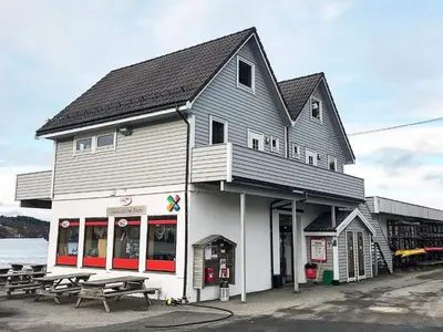 a building with picnic tables in front of it at 6 person holiday home in Seim in Seim