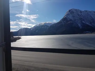 a view of a snowy mountain from a train window at Vasstun Panorama in Odda