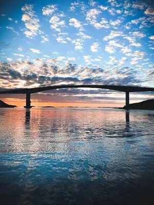a bridge over a body of water with a cloudy sky at Villa Edvin - Slow living in Eide