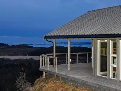 a house with a deck on top of a hill at 6 person holiday home in Lyngstad in Lyngstad