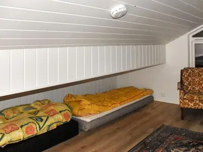 two beds are sitting in a room with a wall at 6 person holiday home in Lyngstad in Lyngstad
