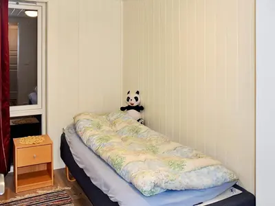 a bed in a room with a panda stuffed animal at 6 person holiday home in Lyngstad in Lyngstad