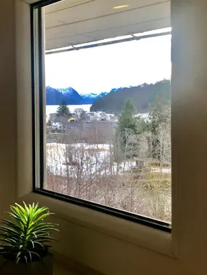 a window with a view of a snow covered field at Villa Lovise Riverside in Stranda