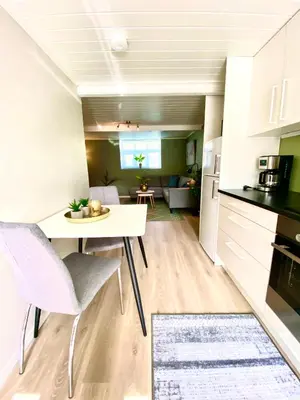 a kitchen and living room with a table and chairs at Villa Lovise Riverside in Stranda