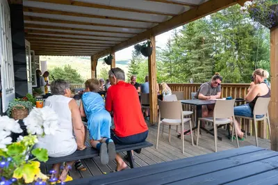 a group of people sitting at tables on a deck at Topcamp Rustberg - Hafjell in Hafjell