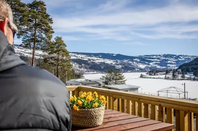 a person sitting on a deck with a basket of flowers at Topcamp Rustberg - Hafjell in Hafjell