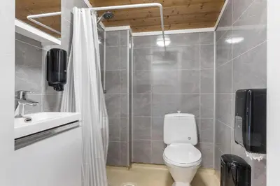 a bathroom with a white toilet and a sink at Topcamp Rustberg - Hafjell in Hafjell