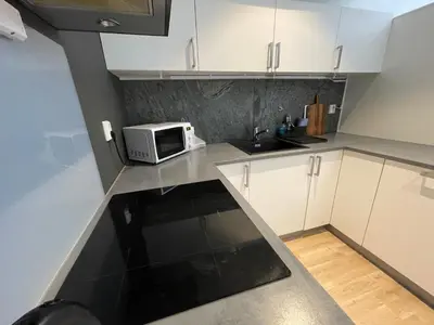 a kitchen with white cabinets and a microwave at Apartment Lilletveitvegen in Bergen