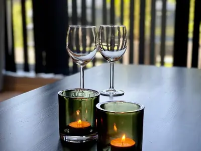 two wine glasses and candles on a table at Apartment Lilletveitvegen in Bergen