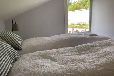 two beds sitting next to a window in a bedroom at Moldegaard Riding Lodge in Moldegard