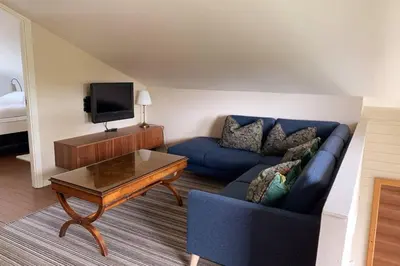a living room with a blue couch and a coffee table at Moldegaard Riding Lodge in Moldegard