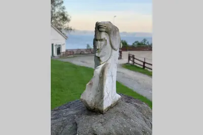 a statue of a woman sitting on a rock at Moldegaard Riding Lodge in Moldegard