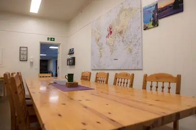 a conference room with a large wooden table and chairs at Sognhostel in Sørbø