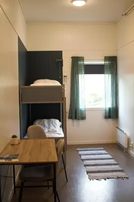 a room with a table and a bunk bed at Sognhostel in Sørbø