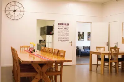 a dining room with a wooden table and chairs at Sognhostel in Sørbø