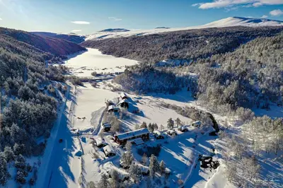 an aerial view of a mountain with snow and trees at Rondane River Lodge - Rondane Gjestegård in Enden