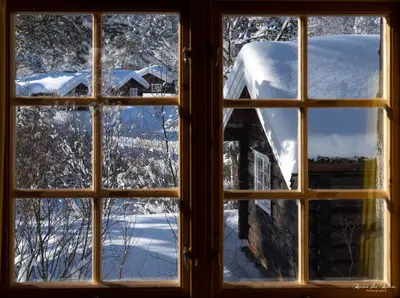 a window looking out at a snow covered yard at Rondane River Lodge - Rondane Gjestegård in Enden