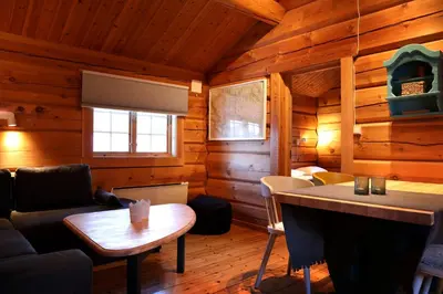 a living room in a log cabin with a fireplace at Rondane River Lodge - Rondane Gjestegård in Enden