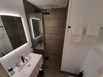 a white bathroom with a sink and a shower at Rondane River Lodge - Rondane Gjestegård in Enden