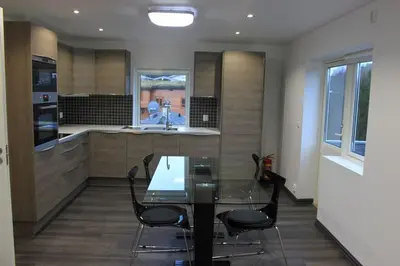 a kitchen with a glass table and black chairs at Lagunen Apartments in Bergen
