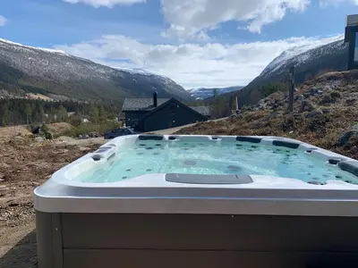 a hot tub with a view of a mountain at Hyggelig laftehytte på 140kvm med Ski-In/Out in Uvdal
