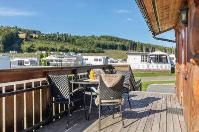 a patio with two chairs and a table on a deck at Topcamp Mjøsa - Brumunddal in Brumunddalen