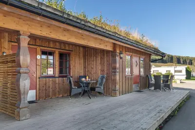 a wooden deck with a table and chairs on it at Topcamp Mjøsa - Brumunddal in Brumunddalen