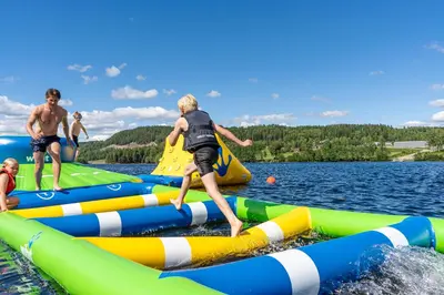 a group of people playing on inflatables in the water at Topcamp Mjøsa - Brumunddal in Brumunddalen
