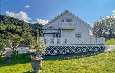 a white house with a porch on a hill at Cozy Home In Etne With Wifi in Kyrping
