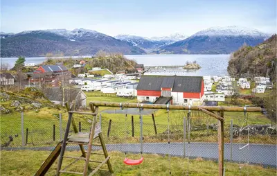a playground with a chair and a lake and mountains at Cozy Home In Etne With Wifi in Kyrping