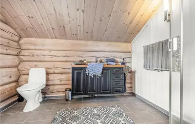 a bathroom with a toilet and a wooden wall at 4 Bedroom Stunning Home In Hemsedal in Hemsedal