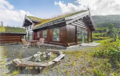 a cabin with a grass roof with a table and chairs at 4 Bedroom Stunning Home In Hemsedal in Hemsedal