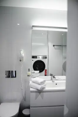 a bathroom with a sink and a washing machine at Panorama Rorbusuiter in Steinsland